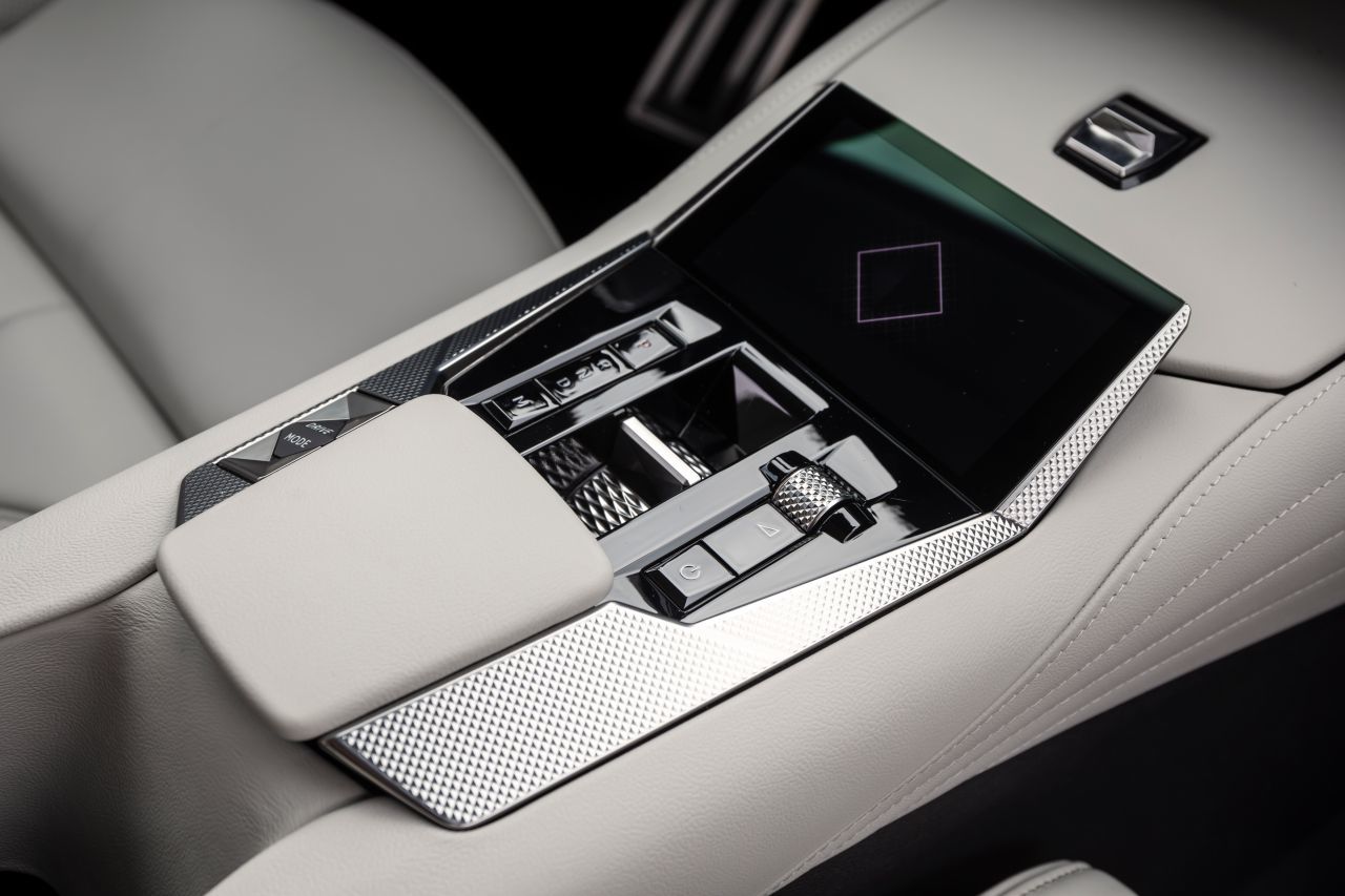 Die Mittelkonsole ist ein liebevoll gestaltetes Gesamtkunstwerk aus Leder, Glas und Metall. Kleiner Touchscreen für Infotainment-Shortcuts.