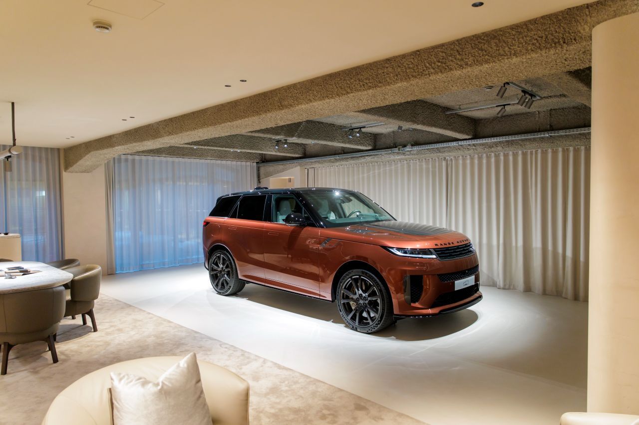 Edles Ledergestühl, massive Holztische und ein großzügiger Empfangsbereich: Das Bespoke Studio ist eine elegante Umgebung in hellen Beigetönen.