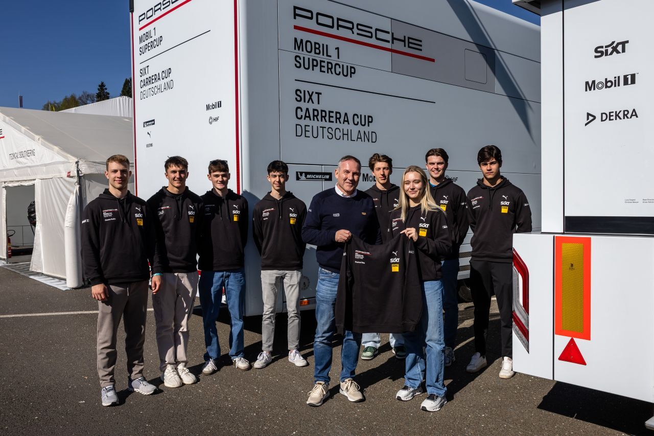 ADAC Motorsportchef Thomas Voss (Mitte) bekam von den Talent Pool Piloten des Porsche Sixt Carrera Cup Deutschland symbolisch einen Hoodie überreicht