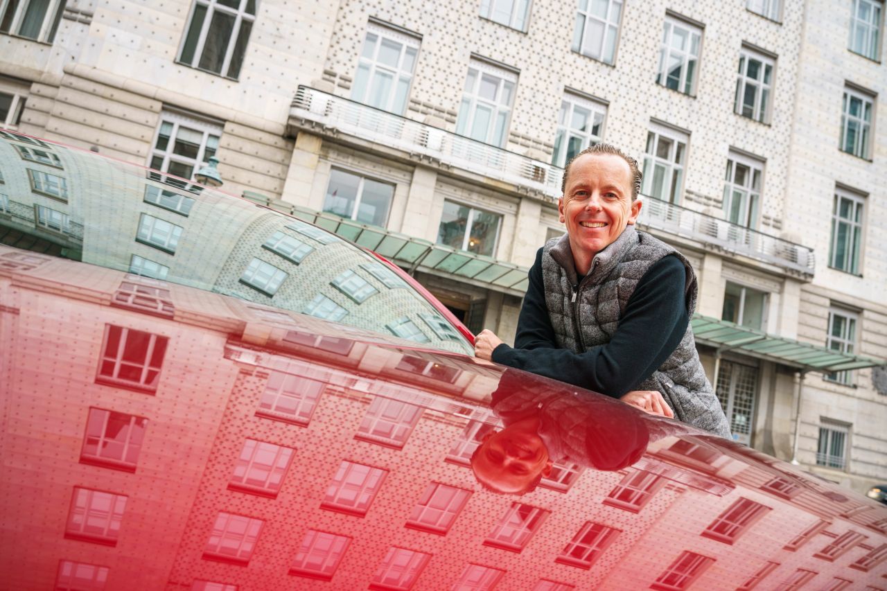Motorprofis-Redakteur Fabian Steiner mit dem Mazda3. Gespiegelt wird die berühmte Nieten-Fassade vom Gebäude der Österreichischen Postsparkasse.
